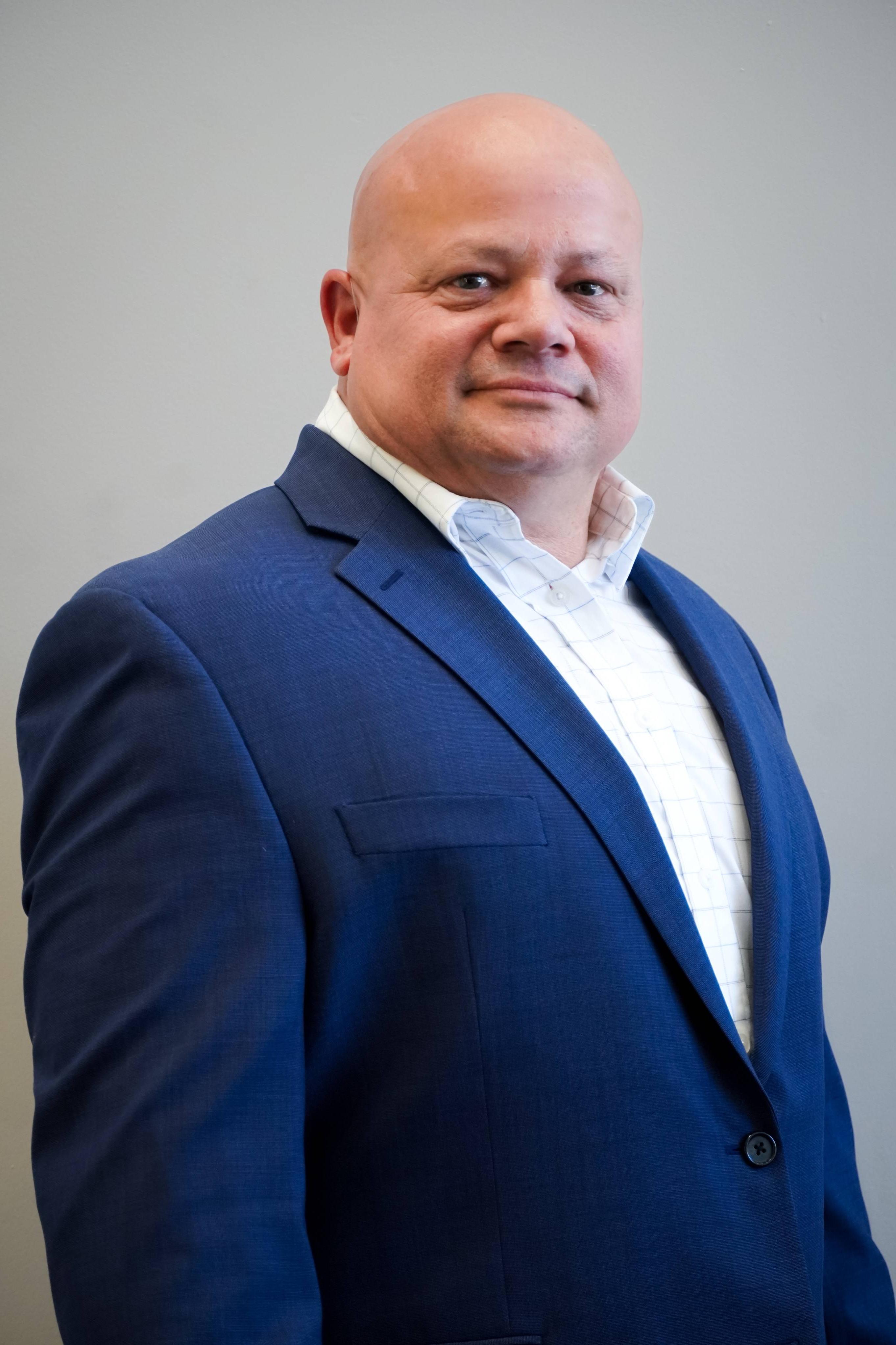 Headshot of Mike Gehrich. He is wearing a dress shirt and blazer jacket. 